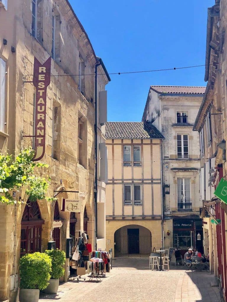 Rue piétonne pittoresque avec restaurants et boutiques.