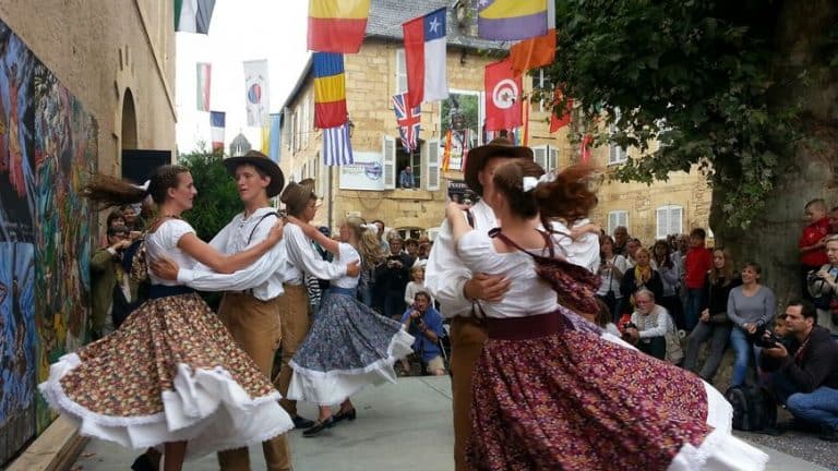 Danse folklorique traditionnelle en costumes colorés.