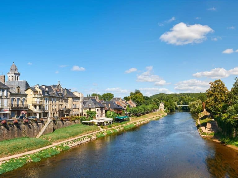 Vue sur la rivière et maisons traditionnelles françaises.